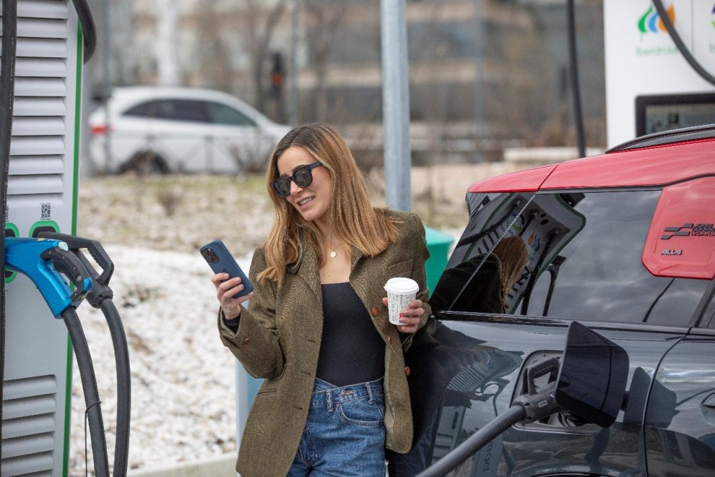 chica cargando coche con cafe