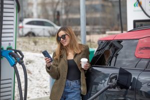 chica cargando coche con cafe